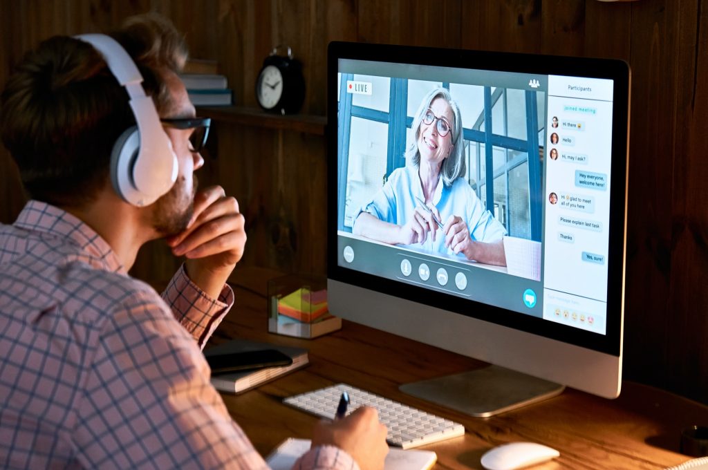 male-student-wearing-headphones-taking-online-course-seminar-watching-webinar-