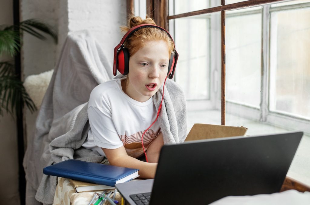the-schoolgirl-is-studying-remotely-child-with-headphones-and-a-laptop-online-courses-